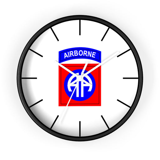 The 82nd Airborne Wall Clock, known for its high quality, features a sleek black frame and a pristine white face. At the center of the face is the insignia of the U.S. Army's 82nd Airborne Division, displaying a blue "AIRBORNE" tab above a red rectangle with a white and blue double "A" logo. Encircling the clock face are black hour marks that add an elegant touch to any personalized space.