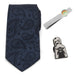 Displayed as the Mando The Child Necktie Gift Set, this package includes a 100% silk navy blue paisley-patterned necktie, a silver tie clip adorned with a small cartoon of a baby in a green blanket, and an enamel lapel pin illustrating the Mandalorian in silver armor holding a tiny character robed in green.