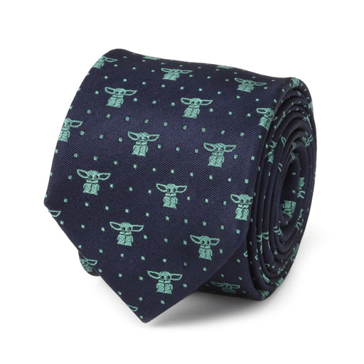 A neatly rolled navy blue silk tie, named "The Child Dotted Navy Boy's Tie," features a pattern of small green alien-like figures that are reminiscent of Yoda Dot. The figures are evenly spaced and surrounded by small green dots.