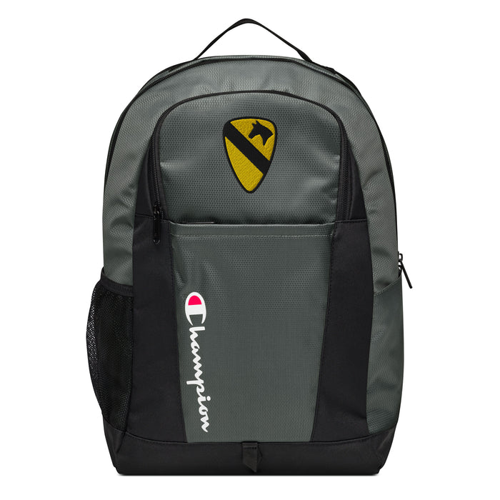 The 1st Cavalry Division Champion Backpack in gray and black showcases a "Champion" logo, a mesh side pocket, a top handle and a 1st Cavalry Division logo on the front. Crafted from water-resistant material, this sports backpack is ideal for all-weather use.