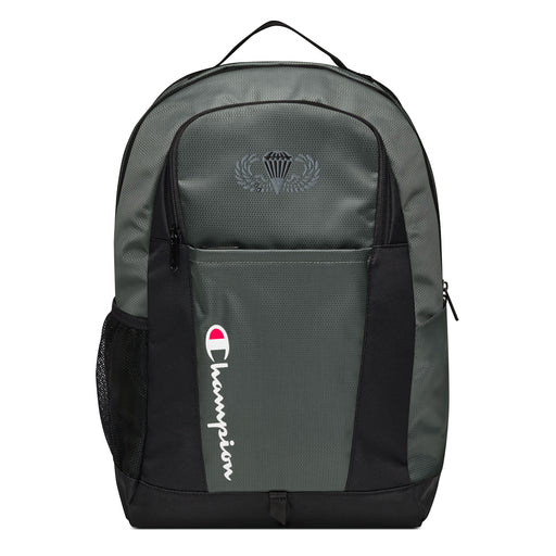 The Basic Parachutist Champion Backpack in gray and black showcases a "Champion" logo, a mesh side pocket, a top handle and a Basic Parachutist logo on the front. Crafted from water-resistant material, this sports backpack is ideal for all-weather use.