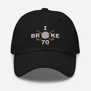 The "I Broke 70" Men's Embroidered Hat is a black, low-profile hat featuring the phrase "I Broke 70" on the front. The word "Broke" is uniquely stylized with a golf ball as the 'O' and crossed golf clubs beneath it.