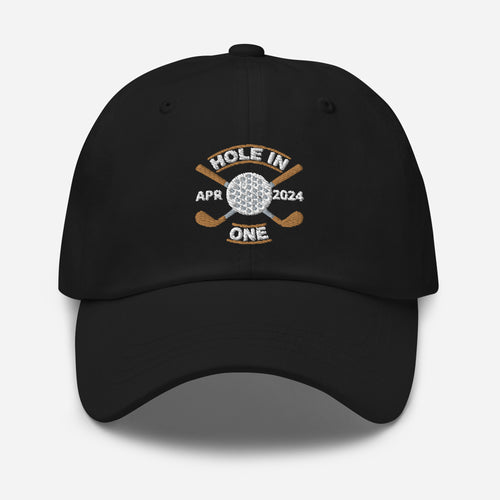 The Golf Hat in black - Hole in One with Personalized Month and Year features a golf design  including two crossed golf clubs with a golf ball at the center and the text "HOLE IN ONE" above. Customized month and year are on the left and right sides.