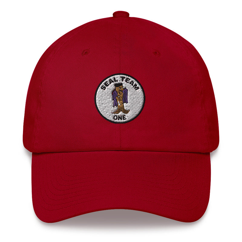 A cranberry colored Seal Team 1 Hat with the logo on the front.  The hat has a curved visor and an adjustable strap at the back.