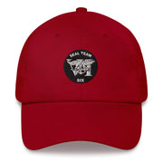A cranberry colored Seal Team 6 Hat with the logo on the front.  The hat has a curved visor and an adjustable strap at the back.