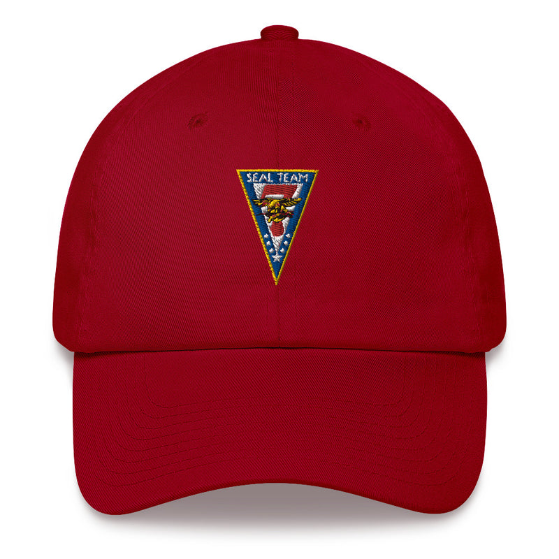 A cranberry colored Seal Team 7 Hat with the logo on the front.  The hat has a curved visor and an adjustable strap at the back.