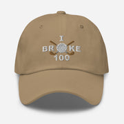 The "I Broke 100" Men's Embroidered Hat is a khaki colored, low-profile hat featuring the phrase "I Broke 70" on the front. The word "Broke" is uniquely stylized with a golf ball as the 'O' and crossed golf clubs beneath it.