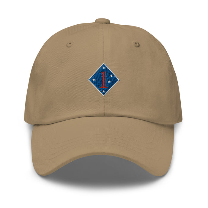 A khaki colored 1st Marine Division Hat with the logo on the front.  The hat has a curved visor and an adjustable strap at the back.
