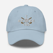 The "I Broke 100" Men's Embroidered Hat is a light blue, low-profile hat featuring the phrase "I Broke 70" on the front. The word "Broke" is uniquely stylized with a golf ball as the 'O' and crossed golf clubs beneath it.