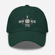 The "I Broke 70" Men's Embroidered Hat is a spruce colored, low-profile hat featuring the phrase "I Broke 70" on the front. The word "Broke" is uniquely stylized with a golf ball as the 'O' and crossed golf clubs beneath it.