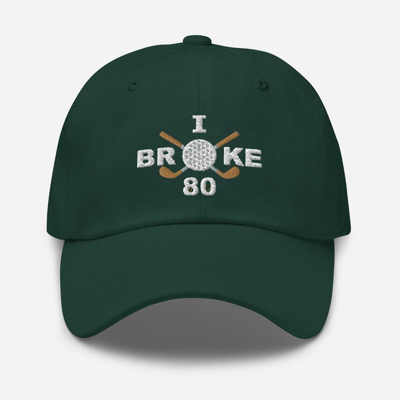 The "I Broke 80" Men's Embroidered Hat is a spruce colored, low-profile hat featuring the phrase "I Broke 70" on the front. The word "Broke" is uniquely stylized with a golf ball as the 'O' and crossed golf clubs beneath it.