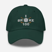 The "I Broke 10" Men's Embroidered Hat is a spruce colored, low-profile hat featuring the phrase "I Broke 70" on the front. The word "Broke" is uniquely stylized with a golf ball as the 'O' and crossed golf clubs beneath it.