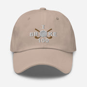 The "I Broke 100" Men's Embroidered Hat is a stone colored, low-profile hat featuring the phrase "I Broke 70" on the front. The word "Broke" is uniquely stylized with a golf ball as the 'O' and crossed golf clubs beneath it.