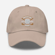 The Golf Hat in stone colored - Hole in One with Personalized Month and Year features a golf design  including two crossed golf clubs with a golf ball at the center and the text "HOLE IN ONE" above. Customized month and year are on the left and right sides.