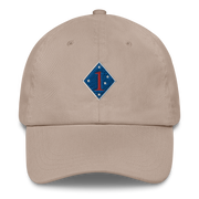 A stone colored 1st Marine Division Hat with the logo on the front.  The hat has a curved visor and an adjustable strap at the back.
