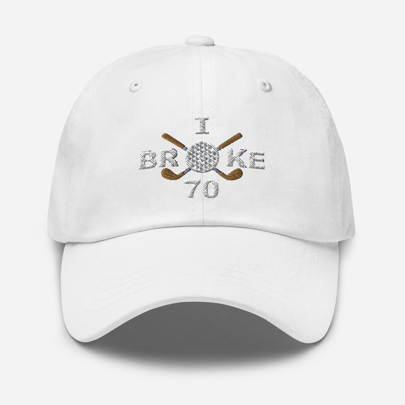 The "I Broke 70" Men's Embroidered Hat is a white, low-profile hat featuring the phrase "I Broke 70" on the front. The word "Broke" is uniquely stylized with a golf ball as the 'O' and crossed golf clubs beneath it.