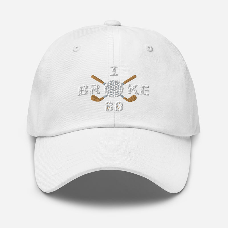 The "I Broke 80" Men's Embroidered Hat is a white, low-profile hat featuring the phrase "I Broke 70" on the front. The word "Broke" is uniquely stylized with a golf ball as the 'O' and crossed golf clubs beneath it.