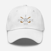 The "I Broke 90" Men's Embroidered Hat is a white, low-profile hat featuring the phrase "I Broke 70" on the front. The word "Broke" is uniquely stylized with a golf ball as the 'O' and crossed golf clubs beneath it.