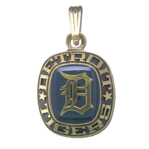 This Detroit Tigers Goldtone Pendant with Enamel features the iconic Old English "D" logo at its center, surrounded by an engraved border that reads "Detroit Tigers" with stars on either side. It is attached to a gold loop for easy attachment to a necklace.