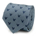 A rolled-up Mickey Silhouette Blue Herringbone Men's Tie made from silk, featuring a zigzag pattern with small, dark blue Mickey Mouse head silhouettes.