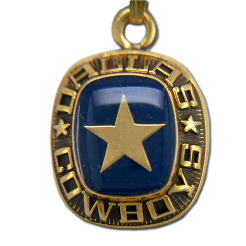 The Dallas Cowboys Goldtone Pendant with Enamel by Balfour Sports features a blue stone adorned with a central silver star, elegantly encircled by "Dallas Cowboys." This design captures both elegance and team spirit.