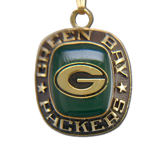 The Green Bay Packers Goldtone Pendant with Enamel showcases a striking "G" at its center, surrounded by the inscription "Green Bay Packers" and adorned with stars on each side. This goldtone pendant has a metallic finish and features a green enamel background behind the "G," making it an ideal accessory for any dedicated fan.