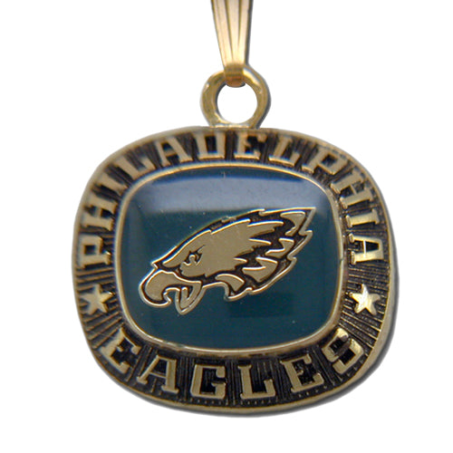 The Philadelphia Eagles Goldtone Pendant with Enamel features the team logo in the center, "PHILADELPHIA EAGLES" engraved around the border, and stars on each side—an ideal piece of NFL jewelry for fans.