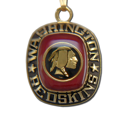 A goldtone Washington Redskins Pendant with a red enamel background displays the text "Washington Redskins" encircling a gold profile of a Native American chief, officially NFL licensed.