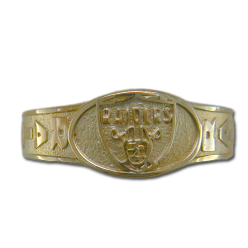 The Oakland Raiders Ring is a 10 Kt gold piece featuring the Raiders football team logo prominently at its center, accompanied by the team's text. The band boasts various intricate and decorative elements to the left and right of the logo, masterfully crafted by designer Michael Anthony.