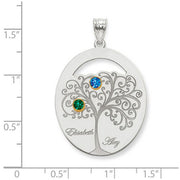 Family Tree Oval Silver Pendant With 2 Birthstones. The pendant is shown on a ruled background.
