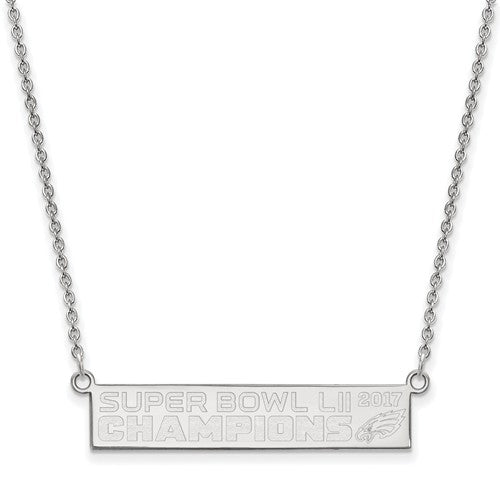 The SS Large Phila Eagles Super Bowl LII Champions Small Bar Necklace is made of sterling silver and features a rectangular pendant engraved with "SUPER BOWL LII CHAMPIONS 2017" along with the Philadelphia Eagles logo. The thin, delicate chain connects to either end of the pendant.