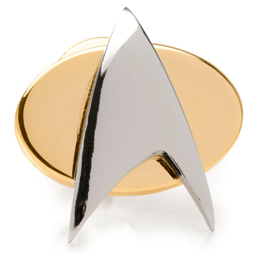 The Two Tone Delta Shield Lapel Pin is a metallic gold oval badge showcasing a striking, polished silver arrowhead-shaped insignia at its center. Sleek and reflective, this piece resembles a finely crafted silver pendant. Dimensions 5/8" x 3/4". The design is officially licensed by CBS Studios Inc., ensuring its authenticity.