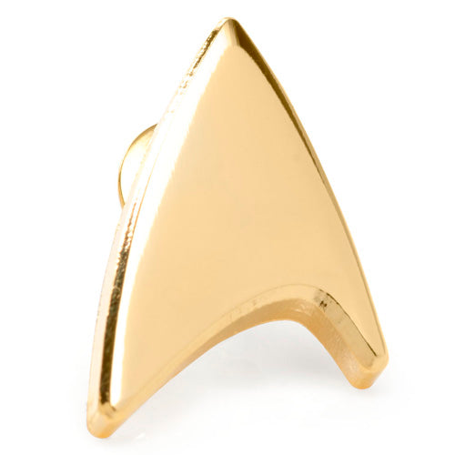 The Gold Delta Shield Lapel Pin from CBS Studios Inc. features a small, arrowhead-shaped design with a smooth, gold surface and a slight curve on one side. It includes a pin fastener at the back and its dimensions accurately replicate the insignia from the "Star Trek" series.
