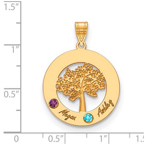 The Circle Pendant With 2 Birthstones is a quality gold accessory featuring a detailed tree in the center. It includes two colored gems: one purple (A) and one blue (B). "Megan" is engraved next to gem A, while "Ashley" is engraved next to gem B. This birthstone pendant has a loop at the top for attaching to a necklace chain. The pendant is shown on a ruled background.