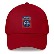 A cranberry colored 82nd Airborne Hat with the logo on the front.  The hat has a curved visor and an adjustable strap at the back.