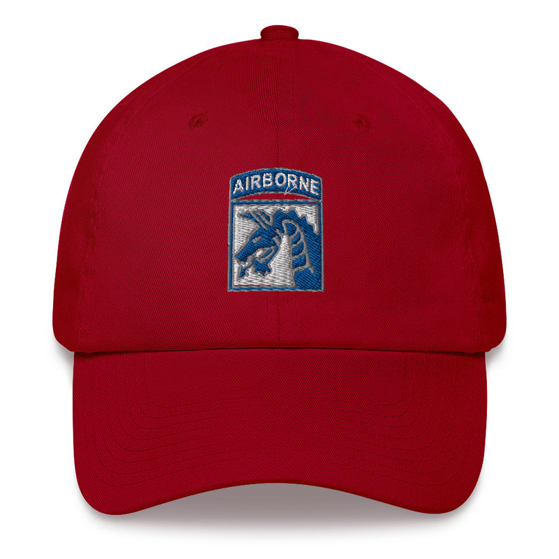 A cranberry colored XVIII Airborne Corps Hat with the logo on the front.  The hat has a curved visor and an adjustable strap at the back.