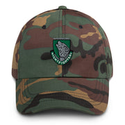 A military style 104th Infantry Division Hat with camouflage and the logo on the front.  The hat has a curved visor and an adjustable strap at the back. 