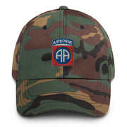 A military style 82nd Airborne Hat with camouflage and the logo on the front.  The hat has a curved visor and an adjustable strap at the back. 