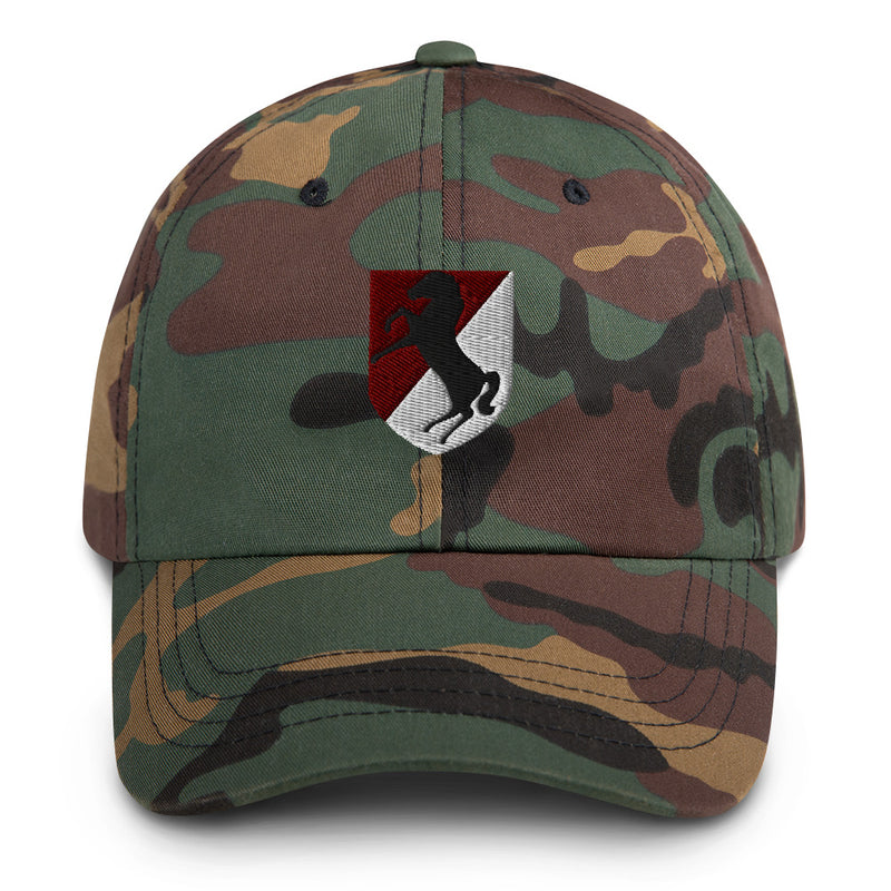 A military style 11th Armored Cavalry Regiment Hat with camouflage and the logo on the front.  The hat has a curved visor and an adjustable strap at the back. 