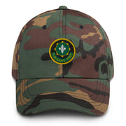 A military style 2nd-cavalry-regiment Hat with camouflage and the logo on the front.  The hat has a curved visor and an adjustable strap at the back. 