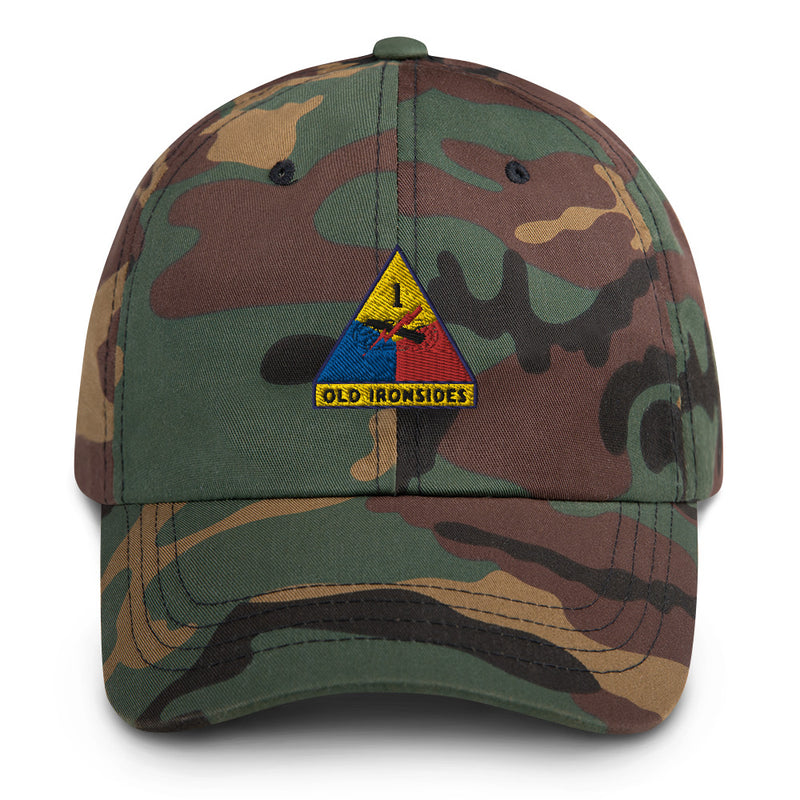 A military style 1st Armored Division Hat with camouflage and the logo on the front.  The hat has a curved visor and an adjustable strap at the back. 