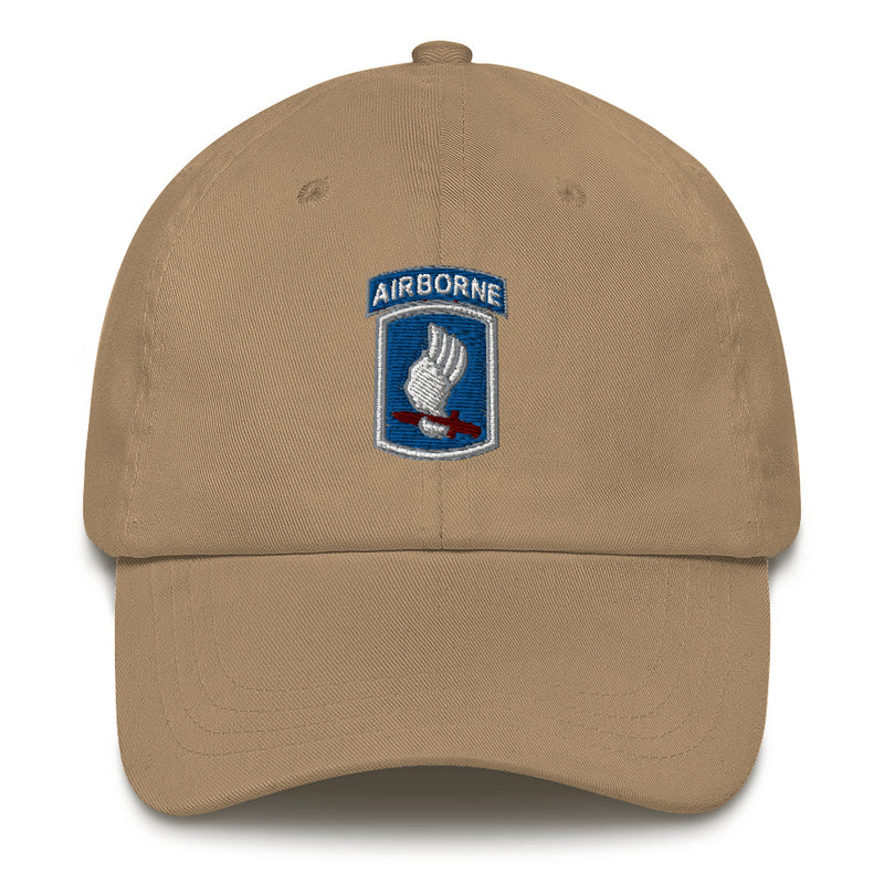 A khaki colored 173rd Airborne Brigade Hat with the logo on the front.  The hat has a curved visor and an adjustable strap at the back.
