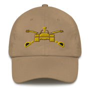 A khaki colored Army Armor Hat with the logo on the front.  The hat has a curved visor and an adjustable strap at the back.