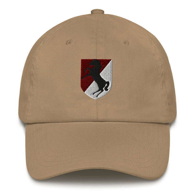 A khaki colored 11th Armored Cavalry Regiment Hat with the logo on the front.  The hat has a curved visor and an adjustable strap at the back.