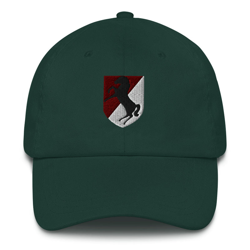 A spruce colored 11th Armored Cavalry Regiment Hat with the logo on the front.  The hat has a curved visor and an adjustable strap at the back.
