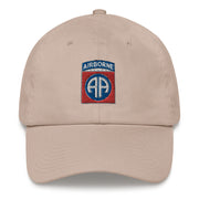 A stone colored 82nd Airborne Hat with the logo on the front.  The hat has a curved visor and an adjustable strap at the back.