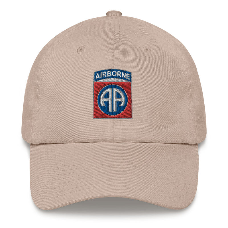 A stone colored 82nd Airborne Hat with the logo on the front.  The hat has a curved visor and an adjustable strap at the back.