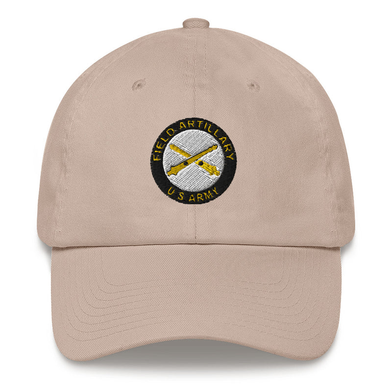A stone colored US Army Field Artillery Hat with the logo on the front.  The hat has a curved visor and an adjustable strap at the back.