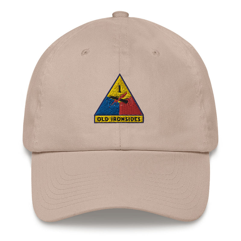A stone colored 1st Armored Division Hat with the logo on the front.  The hat has a curved visor and an adjustable strap at the back.