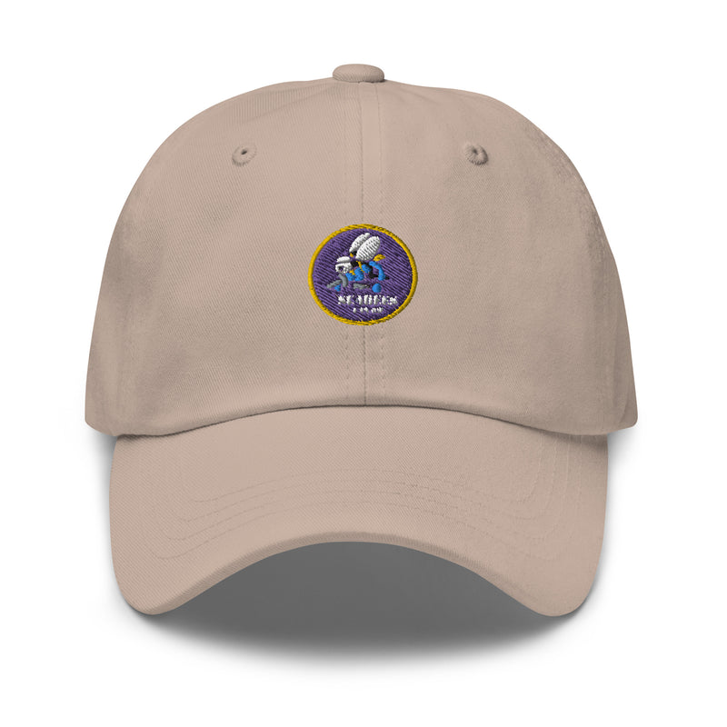 A stone colored Navy Seabees Hat with the logo on the front.  The hat has a curved visor and an adjustable strap at the back.